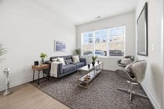 A living room with a grey couch, a coffee table, and a chair.