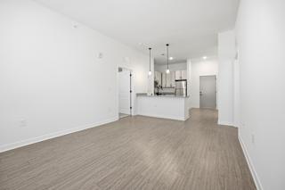 A spacious room with wooden flooring and white walls.