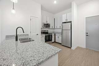 A kitchen with granite countertops and stainless steel appliances.