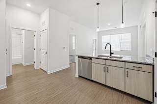 A modern kitchen with wooden floors and white walls.