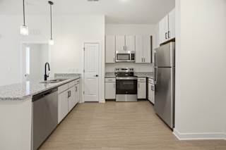 A modern kitchen with stainless steel appliances and white cabinets.