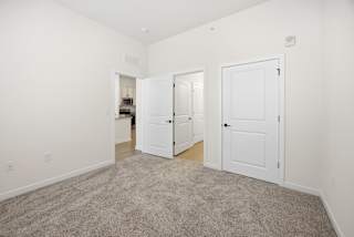A room with three white doors and a carpeted floor.