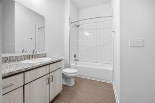 A white bathroom with a toilet, sink, and shower.