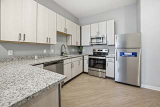 A kitchen with granite countertops and stainless steel appliances.
