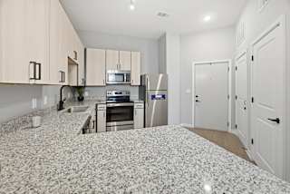 A kitchen with granite countertops and stainless steel appliances.