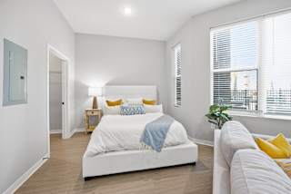 A bedroom with a white bed and a blue blanket.