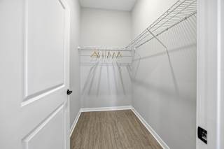 A white door is open to a walk-in closet with a wire shelving system.