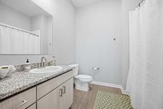 A white bathroom with a sink, toilet, and shower.