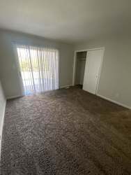 an empty living room with a door to a closet