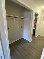 a hallway with wood floors and a closet