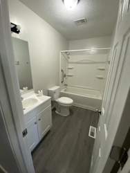 a white bathroom with a toilet and a sink