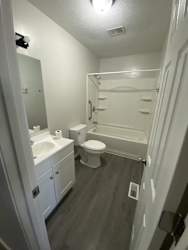 a white bathroom with a toilet and a sink