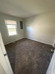 a empty room with carpet and a window