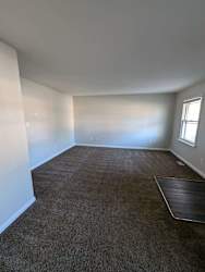 a empty room with a carpeted floor and a window