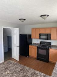 A kitchen with black appliances and wooden cabinets.