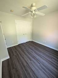 a living room with wood flooring and a ceiling fan