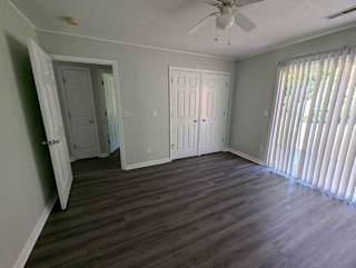 a living room with wood floors and a ceiling fan