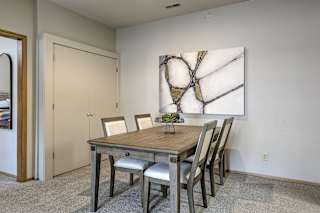 A dining room with a wooden table and chairs. at The Pointe, LaVista