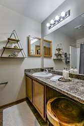 A bathroom with a wooden counter and a round wooden sink. at The Pointe, LaVista, NE