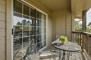 A patio with a table and chairs and a potted plant. at The Pointe, LaVista, Nebraska