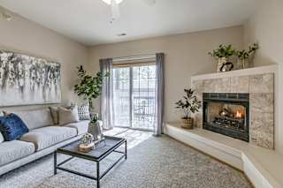 A living room with a fireplace and a couch. at The Pointe, Nebraska, 68128