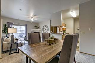 A dining room with a wooden table and chairs. at The Pointe, LaVista, 68128