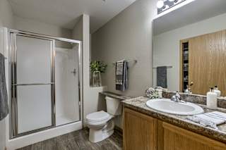 A bathroom with a toilet, sink, and shower. at The Pointe, LaVista, Nebraska