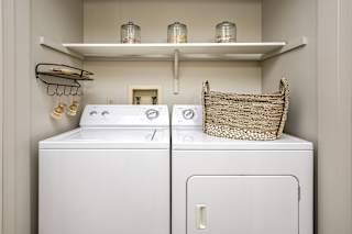 A white washer and dryer in a small laundry room. at The Pointe, LaVista, Nebraska