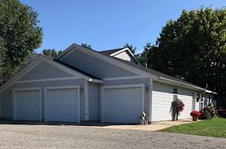 A two-car garage with a white exterior and a grey roof.