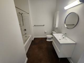 Bathroom with white vanity and tub shower combo at 68 Beale Apartments, Massachusetts, 02169