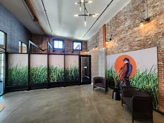 A room with a large mural of a bird on the wall and a glass partition with a view of greenery.