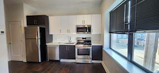 A kitchen with a refrigerator, stove, and oven.