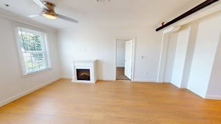 Bedroom with fireplace and ceiling fan at Bostonian Shoe Lofts Apartments, Massachusetts, 02382