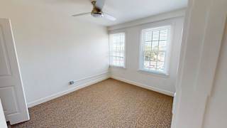 Empty bedroom with carpet and two windows at Bostonian Shoe Lofts Apartments, Whitman, MA 02382