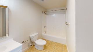 Bathroom with white tub shower and tiled floor at Bostonian Shoe Lofts Apartments, Whitman, MA 02382