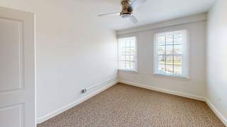 Empty bedroom with windows and tan carpet at Bostonian Shoe Lofts Apartments, Whitman, 02382