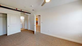 Empty bedroom with carpet and open closet door at Bostonian Shoe Lofts Apartments, Whitman, Massachusetts