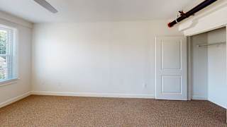 Bedroom with carpet and sliding closet door at Bostonian Shoe Lofts Apartments, Whitman