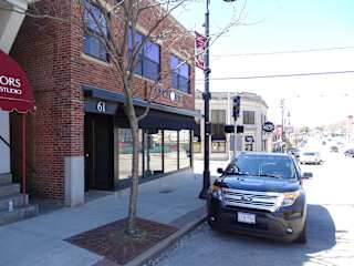 A black SUV is parked on the side of a street.