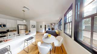 A modern kitchen with a dining table and chairs.
