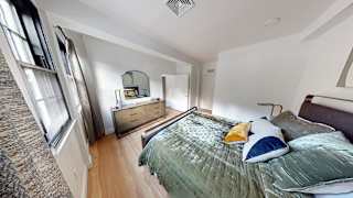 A bedroom with a bed, dresser, and mirror.