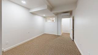 A room with carpeted floor and white walls.