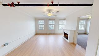 Spacious living room with fireplace and hardwood floors at Bostonian Shoe Lofts Apartments, Whitman, MA 02382