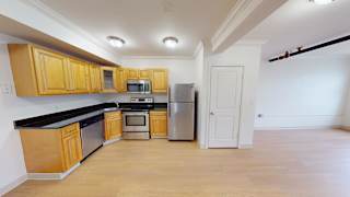 Open kitchen with wood cabinets and black countertops at Bostonian Shoe Lofts Apartments, Whitman, 02382