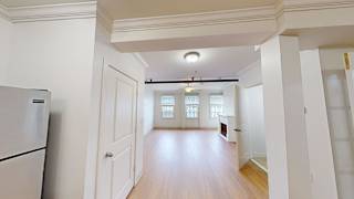 Open floor plan with hardwood flooring and ceiling fan at Bostonian Shoe Lofts Apartments, Whitman