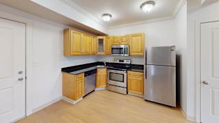 Kitchen with stainless appliances and black countertops at Bostonian Shoe Lofts Apartments, Whitman, Massachusetts