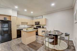 a kitchen with an island and a dining table with chairs at Artisan Apartments & Shops, Austin, Texas, 78729