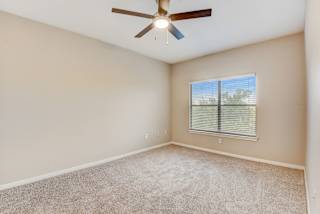 an empty living room with a ceiling fan and a window at Artisan Apartments & Shops, Texas, 78729