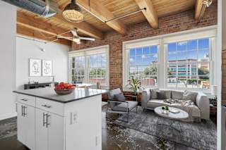 Deep Ellum Lofts Murray building virtually staged kitchen and living area with kitchen island and large windows | Deep Ellum Lofts in Dallas, TX