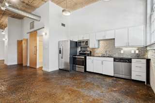 Futura Lofts kitchen with white cabinets and stainless steel appliances | Deep Ellum Lofts in Dallas, TX